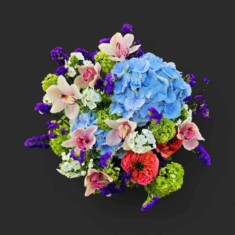 bouquet Genève avec cymbidiums roses, hortensias bleus, renoncules rouges et statice violet – Mélodie d'Équinoxe