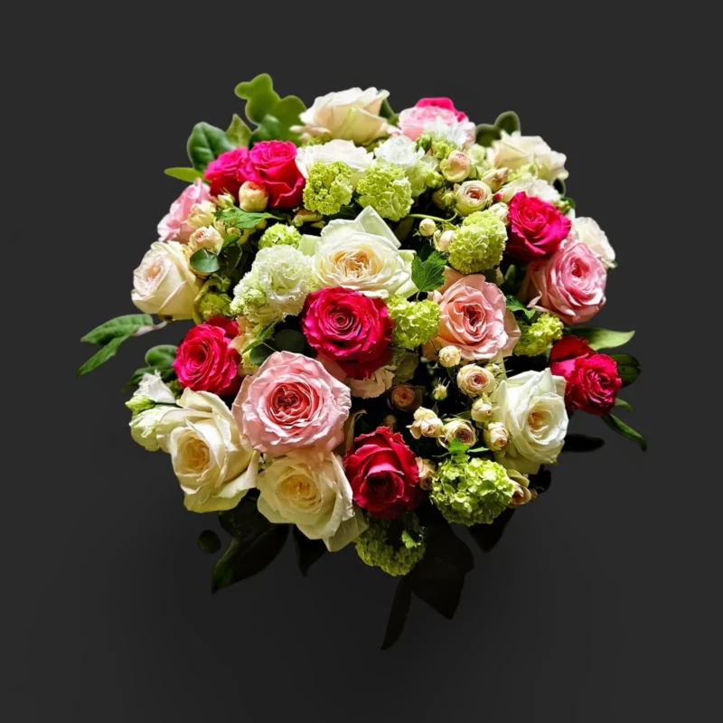 bouquet roses Genève : roses rouges, roses et blanches avec feuillage vert, composition élégante et romantique
